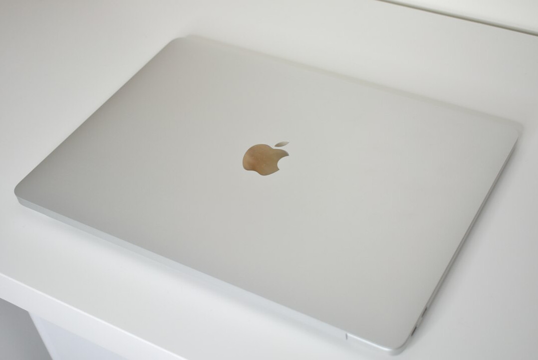 Desk with notebook, pen and laptop
